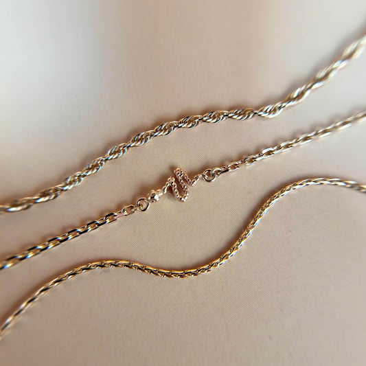 Close-up of a 14ct solid gold snake charm styled on a chain, featuring sleek curves and fine detailing, symbolising transformation and strength in a refined, modern design.