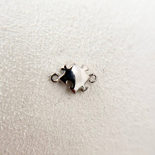Sterling silver jigsaw charm connector, symbolic piece designed for seamless bracelet fit.
