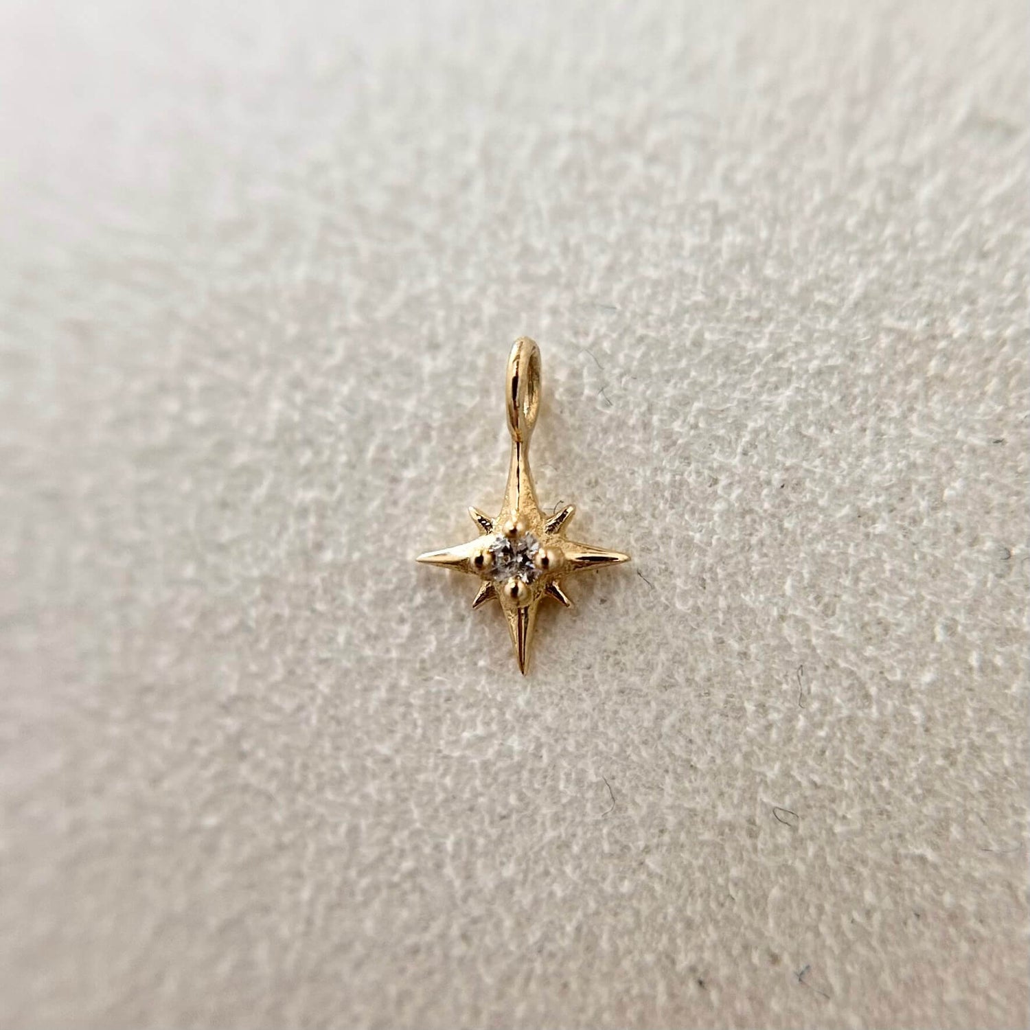 Solid gold star drop charm for permanent jewellery, featuring a delicate dangling star detail, designed to sit seamlessly within custom bracelet or necklace chains.